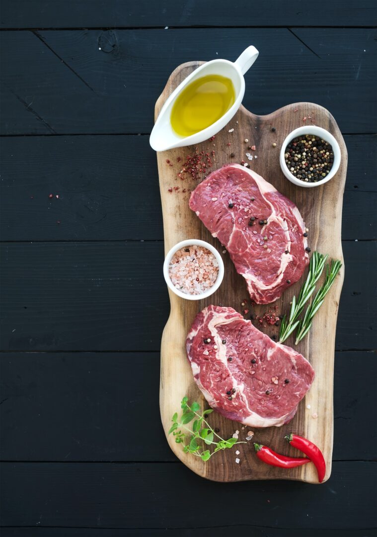 Sliced venison meat on a plate with fresh herbs
